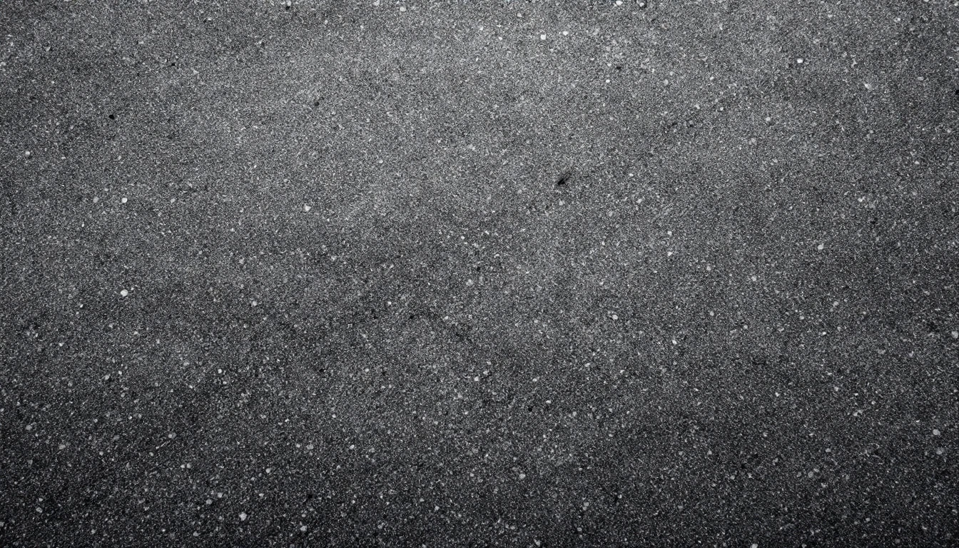 Faded gray asphalt surface with worn aggregate under flat overcast light